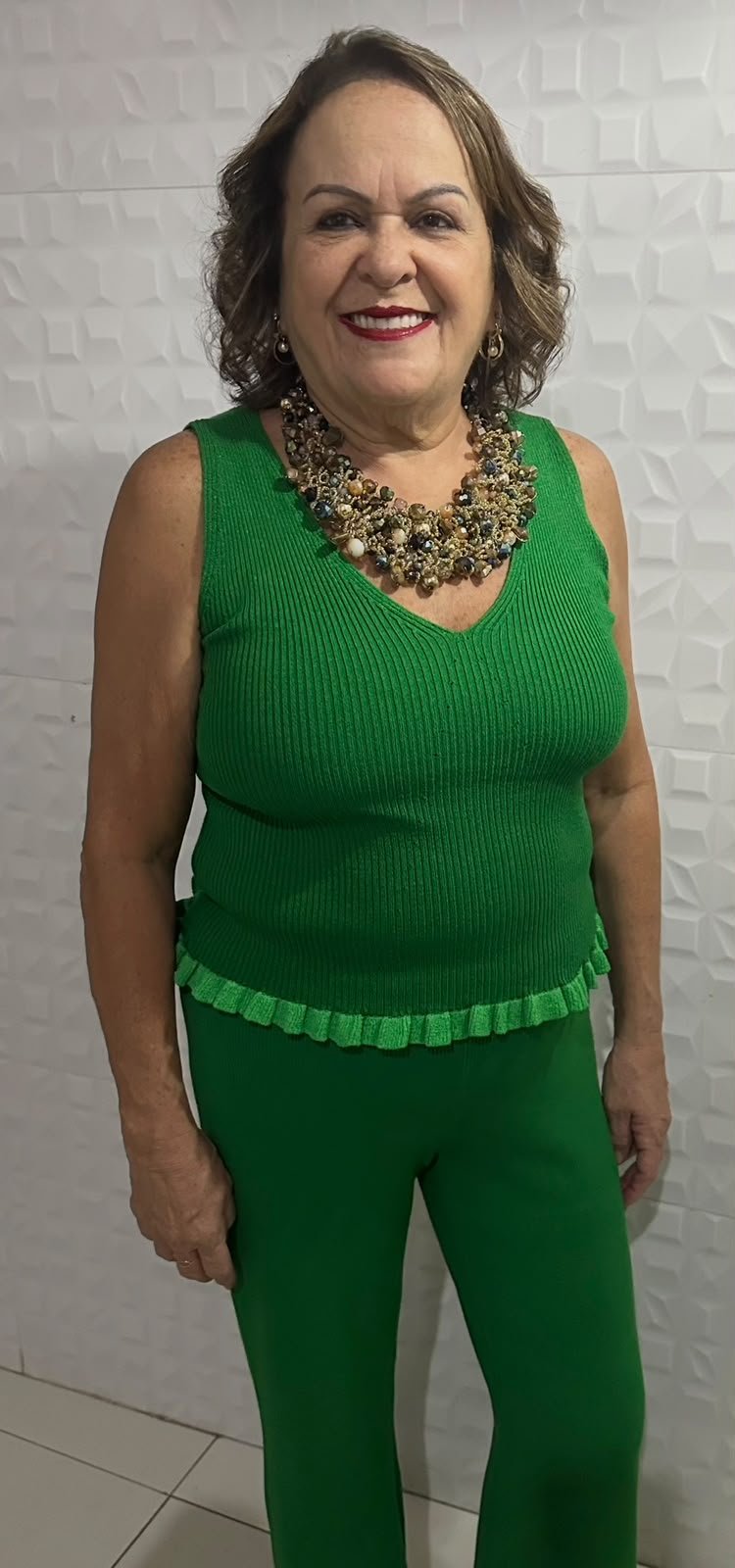 Miriani sorrindo com roupa verde